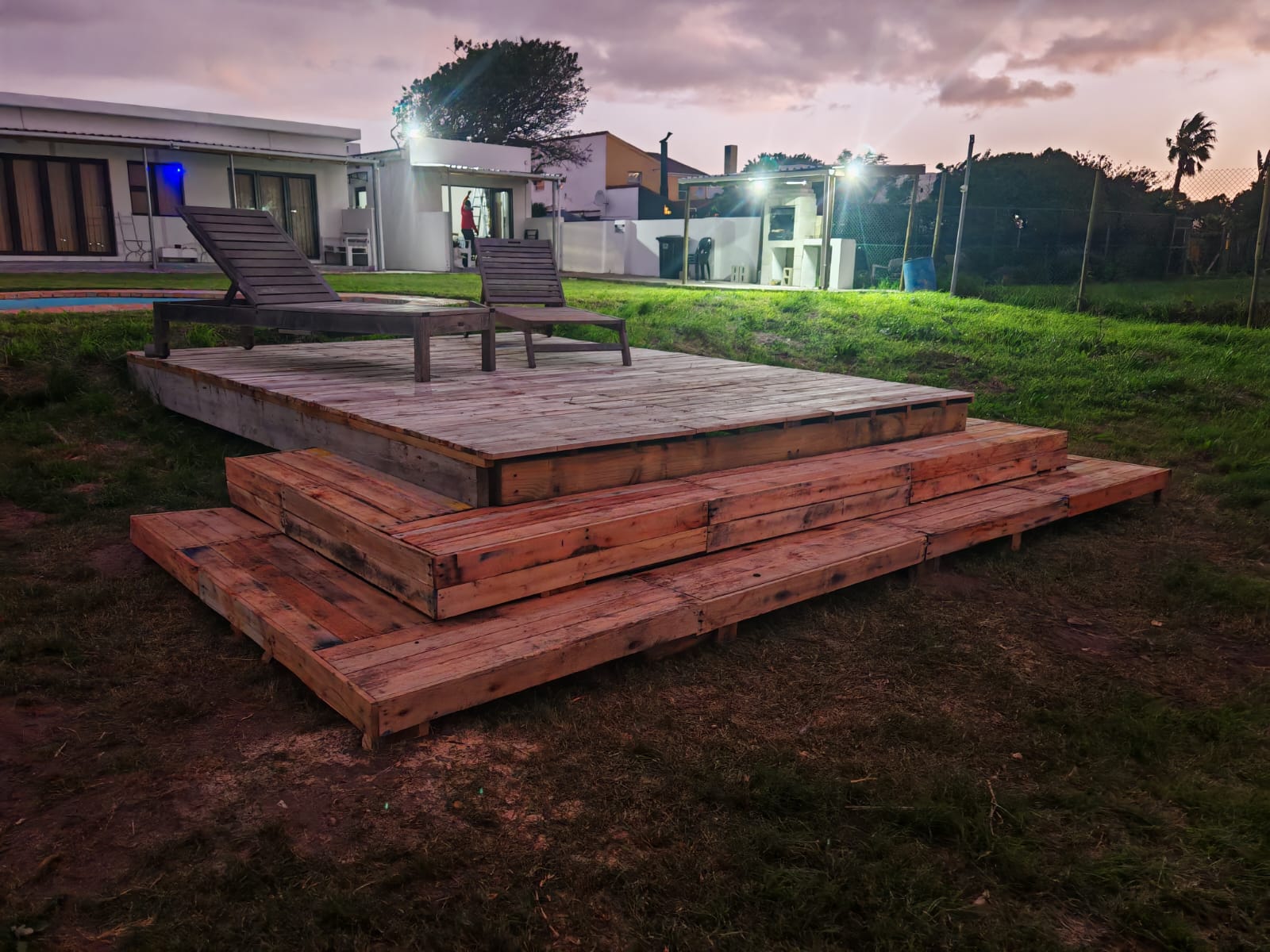 Tiered timber sun deck at dusk — close-up angle